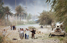 Iraqi men approached a Marine position on the edge of Baghdad as a Cobra helicopter went into the attack